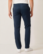 Rear view of man wearing navy Eastern stretch cotton chino pants with white sneakers