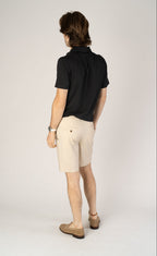 Rear view of man wearing stone Fletch 7.5-inch performance shorts